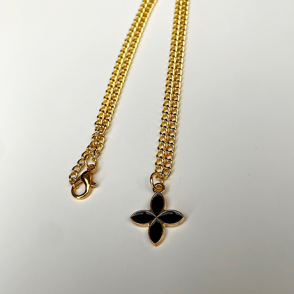 Black charm necklace: gold color metal chain.